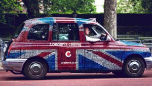 A car wrapped in Great Britain's flag and with an ad on it
