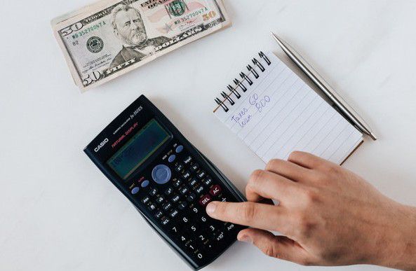 a man using a calculator to calculate extra income